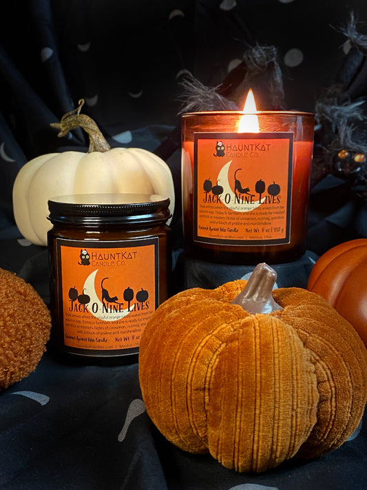 Halloween-themed candles and pumpkins on a dark background