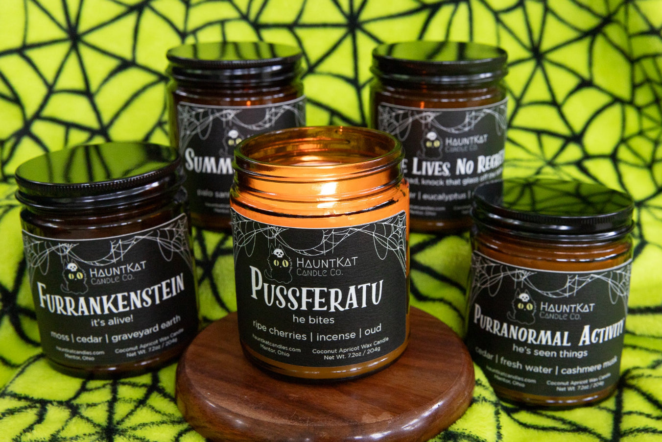Collection of Halloween-themed candles on a spider web background