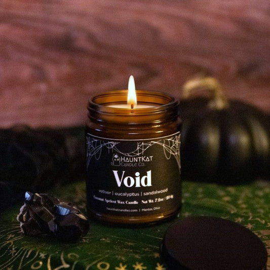 Candle in a jar labeled 'Void' with a dark, witchy background